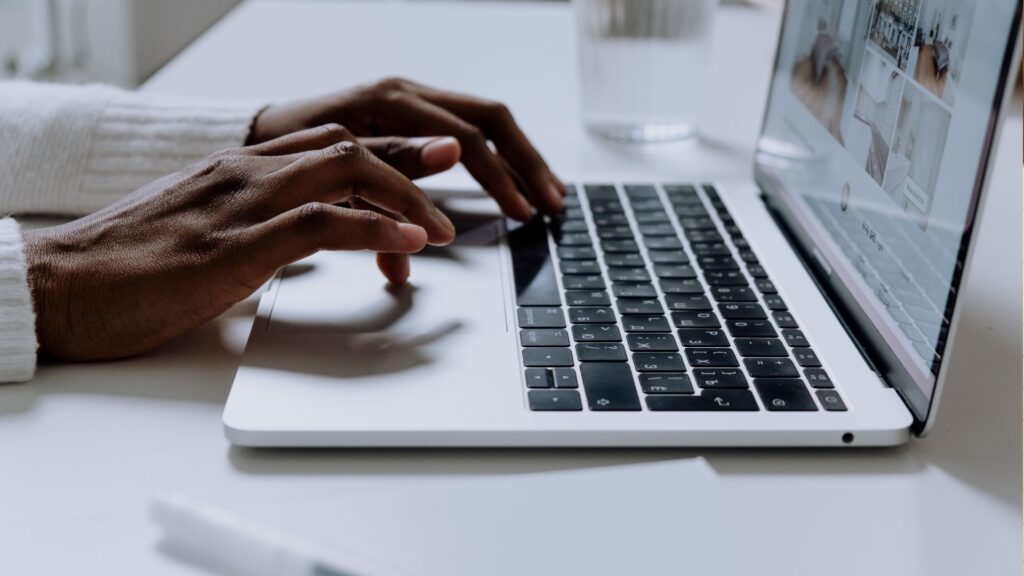 Hands typing on a laptop keyboard