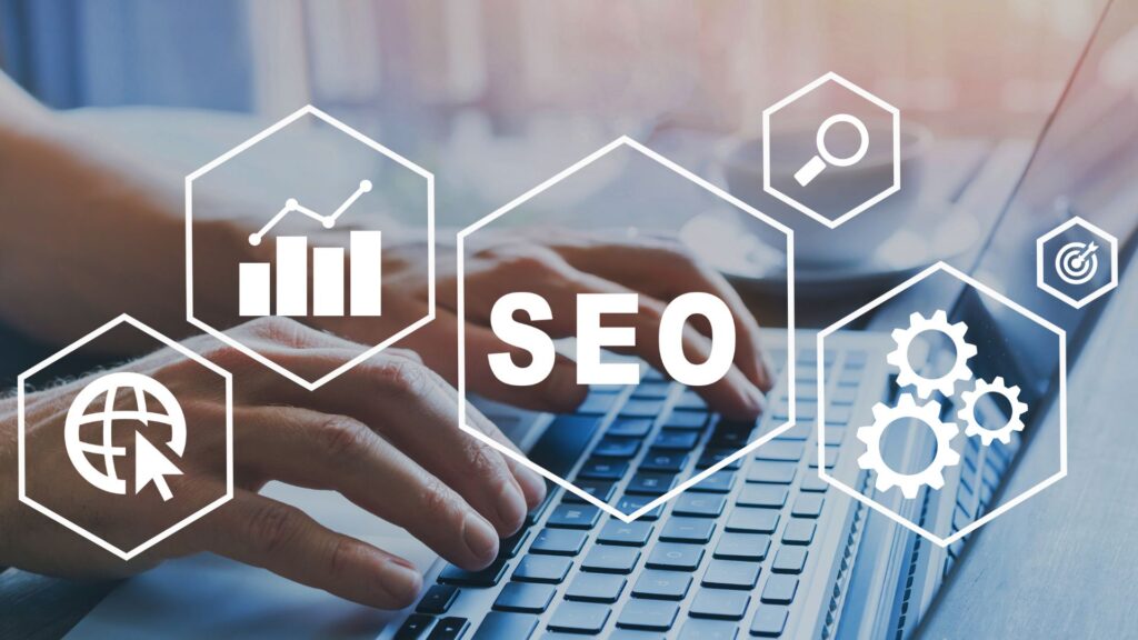 Hands typing on laptop with various icons overlayed. Icons include the acronym "SEO", a globe, a bar graph, gears, and a magnifying glass.