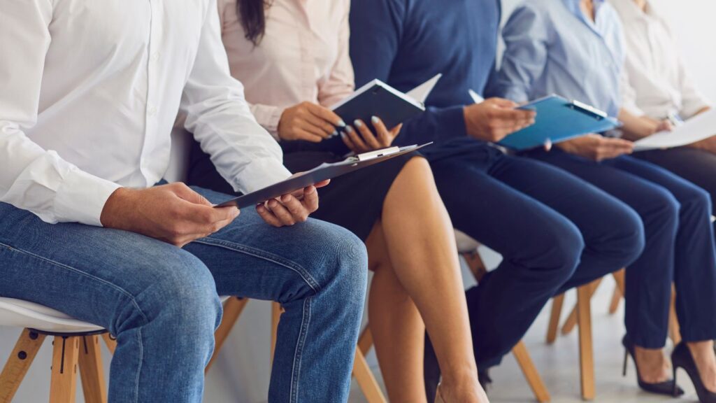 people sitting in chairs holding notebooks