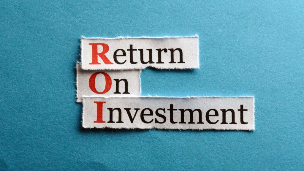 torn paper scraps, each with one of the words "return on investment" on top of a blue background.